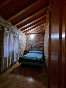 バジェエルモソにあるcasa Luciaのレンガの壁に緑のベッドが備わるベッドルーム1室が備わります。
