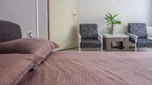 a bedroom with a bed and two chairs and a table at BB Downtown Apartment in Bajina Bašta
