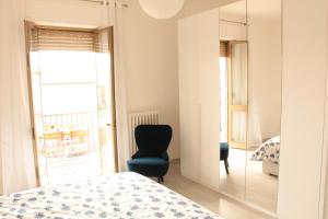 a bedroom with a bed and a chair and a mirror at Alcalù in San Vincenzo
