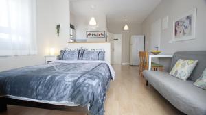 a bedroom with a bed and a couch at Cute & Cozy Studio Apt in Zichron Yaakov in Zikhron Ya‘aqov