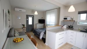 a kitchen and living room with a bed and a table at Cute & Cozy Studio Apt in Zichron Yaakov in Zikhron Ya'akov