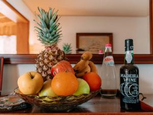 un bol de fruta en una mesa junto a una botella de vino en Atlantic View Penthouse, en Funchal 20 fotos más