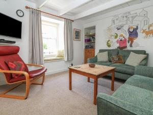 a living room with a couch and a table at Mural Cottage in Mousehole