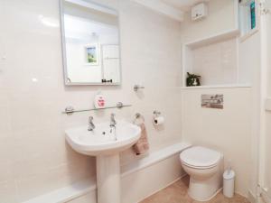 ein weißes Badezimmer mit Waschbecken und Toilette in der Unterkunft Mural Cottage in Mousehole + 23 Fotos