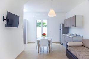 a living room and kitchen with a table and a couch at Ungaretti Resort in Porto Cesareo