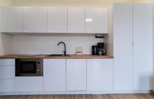 a kitchen with white cabinets and a counter top at Aston Vila Apartments in Dziwnów