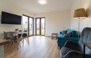 Aston Vila Apartments في جيفنوف: غرفة معيشة مع أريكة زرقاء وطاولة