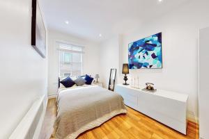 a white bedroom with a bed and a window at Park Lane apartments Jermyn street in London