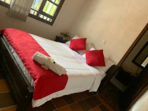 a red and white bed with two red pillows at Hotel Lancers - Pantano de Vargas in Paipa