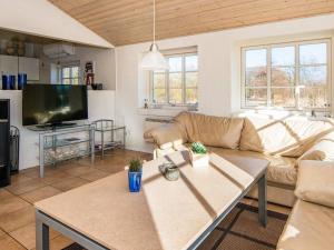 a living room with a couch and a table at Four-Bedroom Holiday home in Ulfborg 9 in Øby