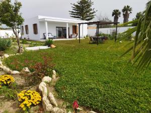 une cour avec une maison et un jardin fleuri dans l'établissement Chalet en Zahora/Caños de Meca, à Zahora
