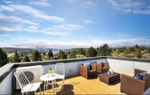 un patio con sedie e tavoli su un balcone di Rooftop Patio with Waterview, Private Garden & Grill 3BR 3BA- Modern Cityscape a Seattle