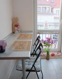 a table and chairs in a room with a window at Apartment Studio BOSSANOVA in Bydgoszcz