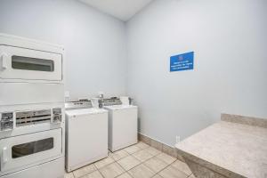 a kitchen with white appliances and a blue sign on the wall at Motel 6-Houston, TX - Spring in Houston