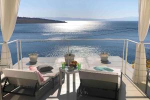 a balcony with a table and chairs and the ocean at Happy Beach Apartment - Dream on the Beach in Kraljevica +46 photos