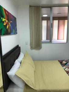 Bett in einem Zimmer mit 2 Fenstern in der Unterkunft Apartamentos Amoblados JG de la 70 in Medellín