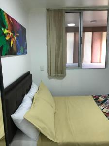 una cama en una habitación con dos ventanas en Apartamentos Amoblados JG de la 70, en Medellín 84 fotos más