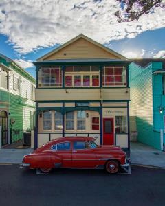 un viejo coche rojo estacionado frente a un edificio en Sea Breeze B & B, en Napier