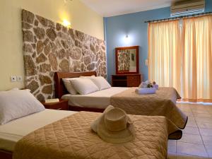 a hotel room with two beds with a hat on top at Dimarion Villas in Agios Nikitas +59 photos
