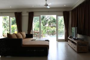 乌布珠玛酒店的带沙发和电视的客厅