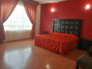- une chambre dotée d'un lit avec un mur rouge dans l'établissement HOTEL XILONEN PALACE, à Jilotepec de Abasolo