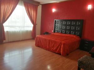 a bedroom with a bed with a red wall at HOTEL XILONEN PALACE in Jilotepec de Abasolo +5 photos