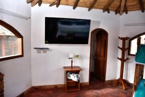 sala de estar con TV en la pared en Hospedaje Plaza Villa de Leyva en Villa de Leyva