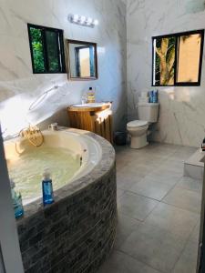 a large bathroom with a tub and a toilet at Castara Inn in Castara +112 photos