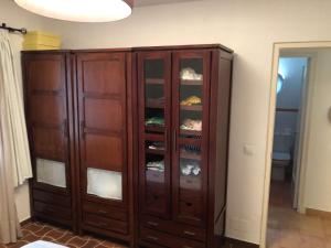 a wooden cabinet with glass doors in a room at Binisafua Playa - Apartamento 24 in Binisafua