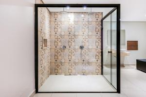 a shower with a glass door in a bathroom at Plaza Motel in Sorocaba