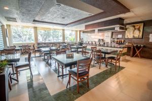 a restaurant with tables and chairs in a room at Real Del Sol - Zona Expo e Industrial in Guadalajara