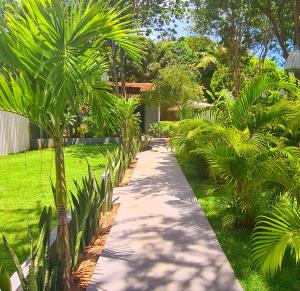 una pasarela en un jardín con palmeras en Pipa Style en Pipa