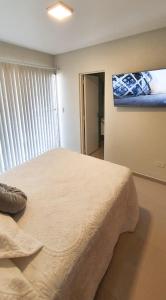 a bedroom with a bed and a tv on the wall at Crisostomo - Bon Repos in San Miguel de Tucumán