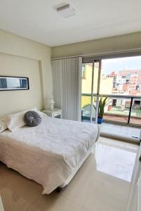 a bedroom with a large bed and a large window at Crisostomo - Bon Repos in San Miguel de Tucumán