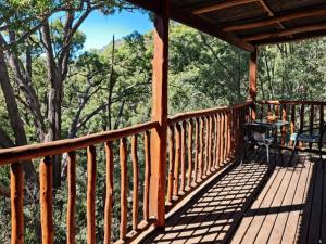 eine Veranda einer Hütte mit Waldblick in der Unterkunft Shady Creek Eco Cabin, Mudgee, Peaceful Country Getaway in Grattai