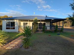 una casa blanca con techo negro y patio en Kangaroo Island Cabins, en Kingscote