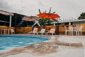 a swimming pool with chairs and umbrellas next to at Keylas Hotel in Ica