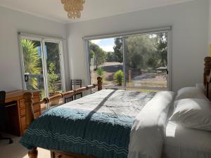 a bedroom with a bed and a large window at Kangaroo Island Cabins in Kingscote