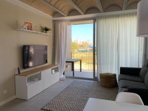 een woonkamer met een tv en een glazen schuifdeur bij Jardins d'Aro in Platja  d'Aro