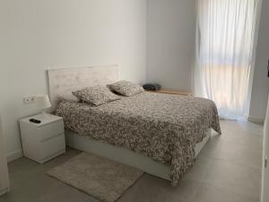 a white bedroom with a bed with a comforter at Jardins d'Aro in Platja  d'Aro +19 photos