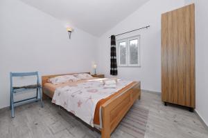 ein Schlafzimmer mit einem Bett, einem Spiegel und einem Stuhl in der Unterkunft House Idro in Pašman