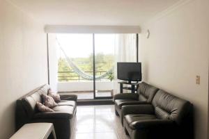 Sala de estar con 2 sofás y TV en Apartamento, sector exclusivo de Villavicencio, en Villavicencio