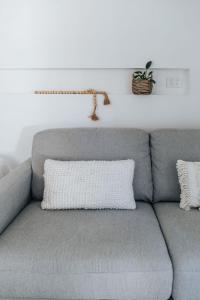 a gray couch with a white pillow on it at Studio on Lewis Tiny House in Mudgee