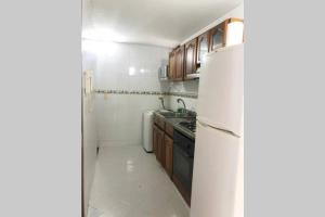 una pequeña cocina con nevera y fregadero en Apartamento, sector exclusivo de Villavicencio, en Villavicencio