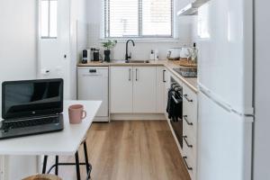 a kitchen with a desk with a laptop on it at Studio on Lewis Tiny House in Mudgee