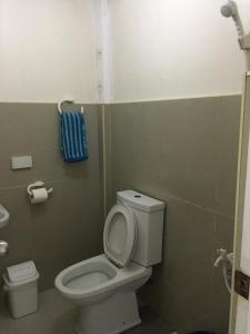 a bathroom with a toilet and a blue towel at Amor En Beach House in Oslob