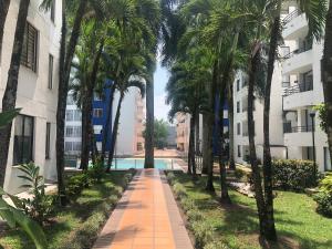 una pasarela a través del patio de un edificio con palmeras en Apartamento, sector exclusivo de Villavicencio, en Villavicencio