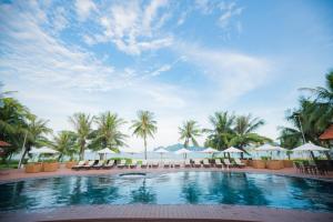 uma piscina no resort com cadeiras e guarda-sóis em Tuan Chau Resort Ha Long em Ha Long