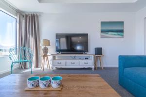 a living room with a tv and a blue couch at Neptune - Lake Tekapo in Lake Tekapo