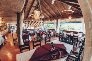 a dining room with tables and chairs and windows at Altos de Caño Hondo in Los Guineos Perdidos